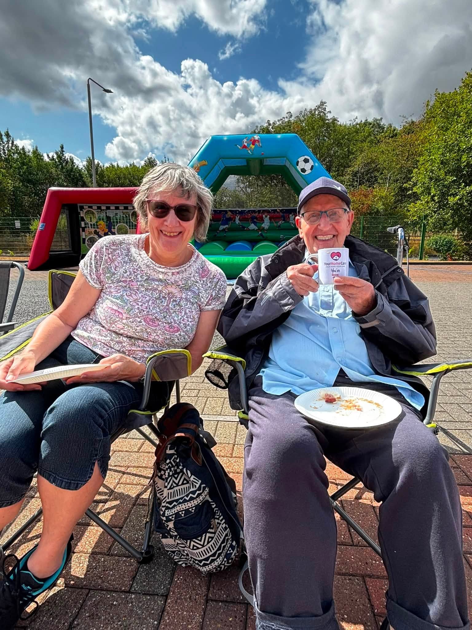 Two guests smiling with food and prize bingo tickets