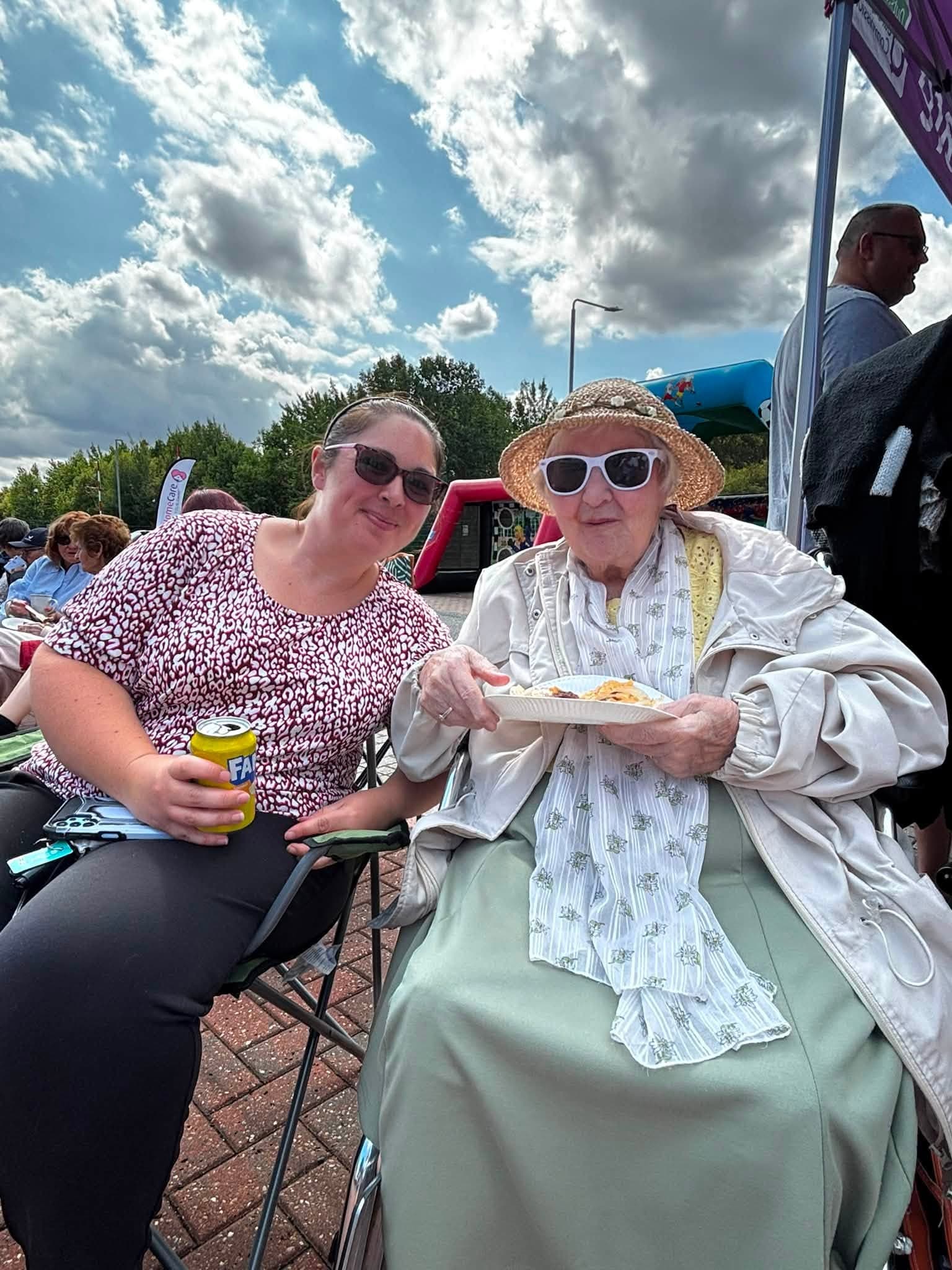 Two guests sharing food and conversation in the sunshine