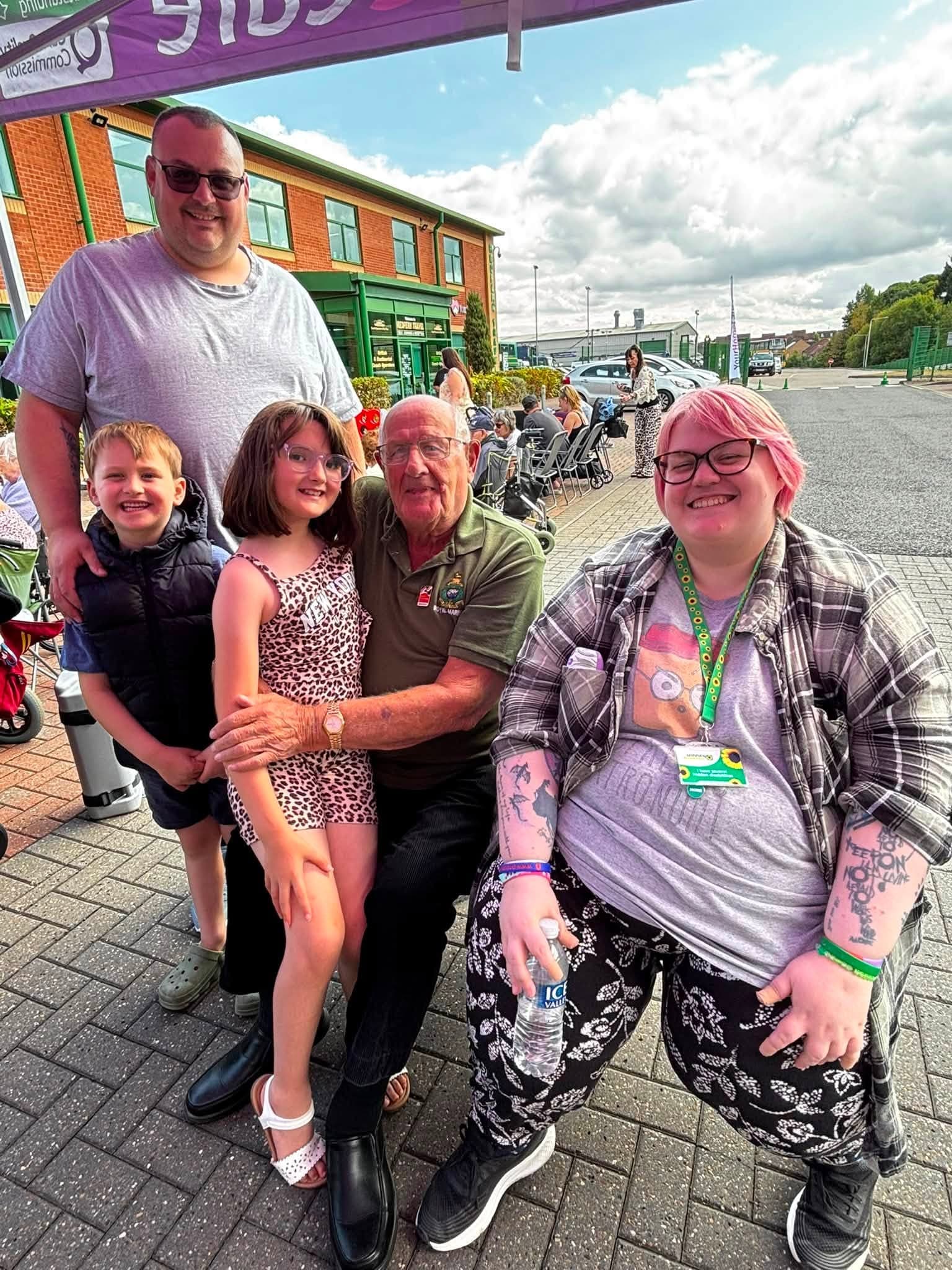 Staff, clients and family members smiling together under the gazebo